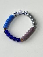 Load image into Gallery viewer, Multicolored beaded bracelet on a light gray background, mostly blue. By Forme Jewellery
