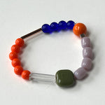 Load image into Gallery viewer, Colorful beaded bracelet  with various beads in shades of orange and blue. on a white background by Forme Jewellery
